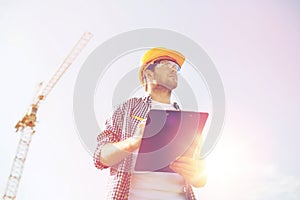 Builder in hardhat with clipboard outdoors