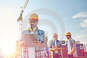 Builder in hardhat with tablet pc at construction