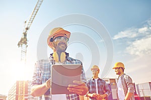 Builder in hardhat with tablet pc at construction