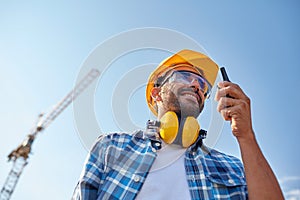 Builder in hardhat with walkie talkie