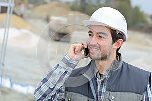 Builder in hardhats on phone outdoors