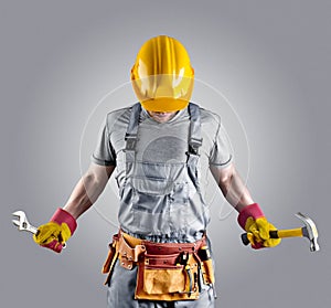 Builder in a helmet with a hammer and a wrench