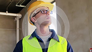 builder in helmet and safety west with tablet pc