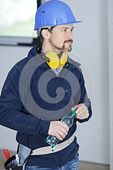 builder holding bottle water while on break