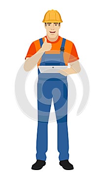 Builder holding digital tablet and showing thumb up