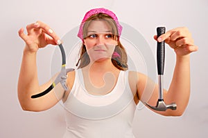Builder holds the hammer and tongs with dislike and antipathy photo