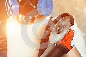 The builder holds in hands Angle grinder.