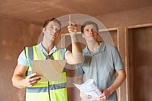 Builder And Inspector Looking At New Property