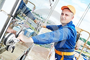 Builder installing glass windows on facade