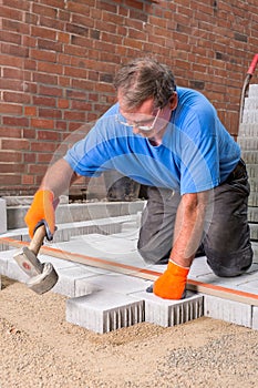 Builder installing new paving stones.