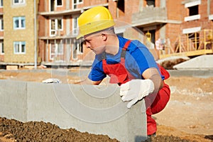 Builder installing road concrete kerb