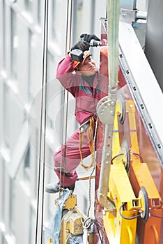 Builder joiner installing glass window on building