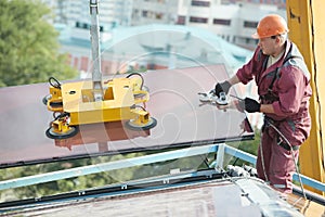 Builder joiner installing glass window on building