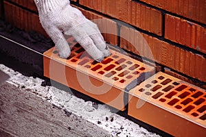 Builder laying bricks on construction site