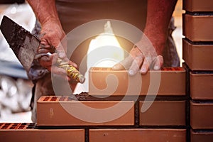 Builder laying bricks on construction site
