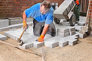 Builder laying new paving stones.