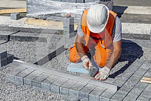 Builder laying paving bricks