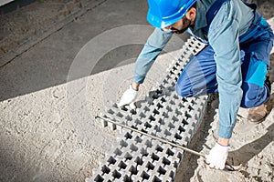 Builder laying paving tiles
