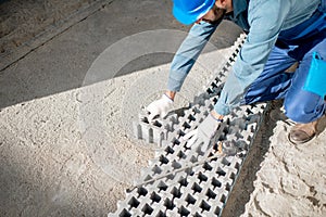 Builder laying paving tiles