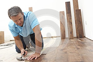 Builder Laying Wooden Flooring photo