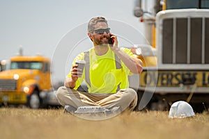 Builder with lunch box and cup of coffee rest. Portrait worker in construction helmet. Engineer builder foreman or