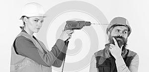 Builder makes hole in male head. Suffer and tolerate concept. Woman drills head of man, white background. photo