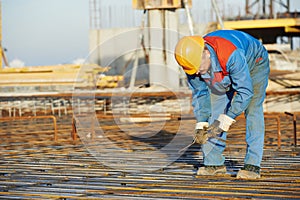 Builder making reinforcement for concrete