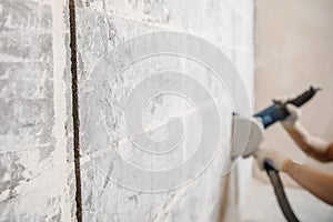 Builder man cutting electrical chase in concrete wall with groove machine diamond crown