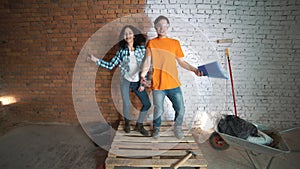 Builder man and the girl with the tool. Make repairs in the house. Dance and rejoice.