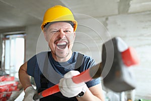 Builder man with a long hammer in his hands