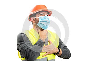 Builder man wearing medical mask making choking gesture