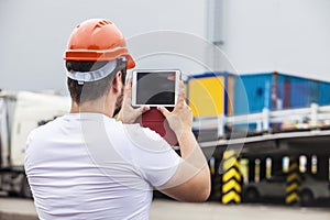 Builder man working with a tablet in a protective helmet
