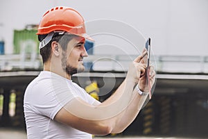 Builder man working with a tablet in a protective helmet