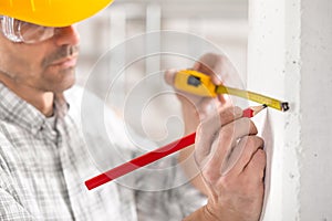 Builder marking off a measurement with a pencil