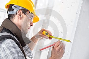 Builder marking off a measurement with a pencil