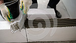 Builder-mason working with aerated concrete blocks. Building walls, placing bricks on a construction site, engineering photo