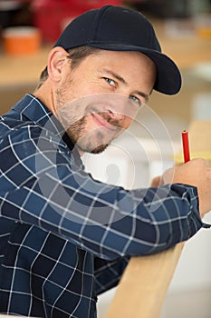 builder measuring window using tape measure and pencil