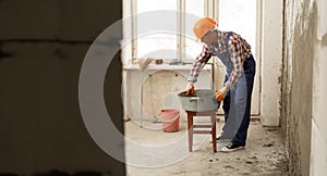 builder mixing mortar to install bricks block on construction site, repair house concept.