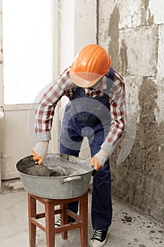 builder mixing mortar to install bricks block on construction site, repair house concept.