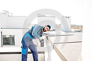 Builder mounting metal cover on the parapet of a new building