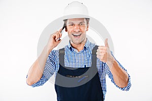 Builder in overall talking on phone and showing thumbs up