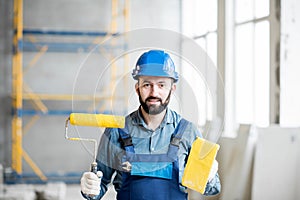 Builder with paint roll indoors
