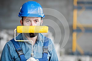 Builder with paint roll indoors