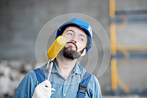 Builder with paint roll indoors