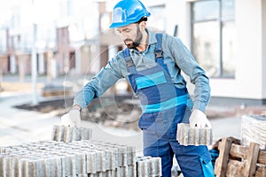 Builder with paving blocks outdoors