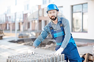 Builder with paving blocks outdoors