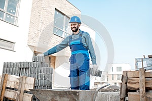 Builder with paving blocks outdoors