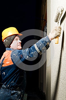 Builder plastering facade wall