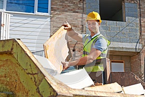 Builder Putting Waste Into Rubbish Skip