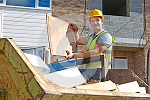 Builder Putting Waste Into Rubbish Skip